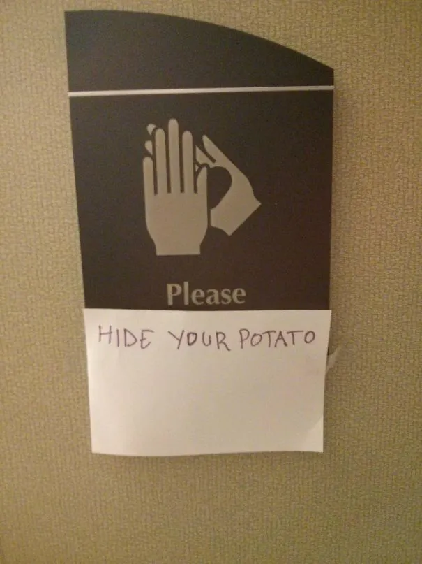 Placa de casa de banho com uma mão e a palavra please, com um papel colado por baixo a dizer esconde a tua batata
