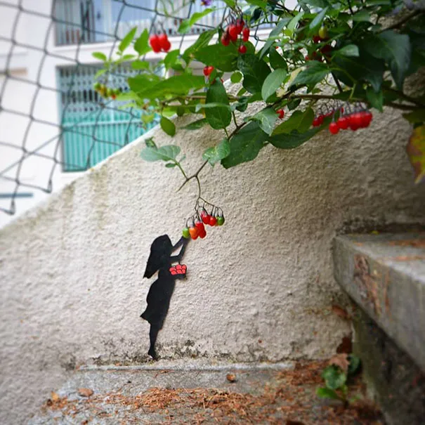 Silhueta pintada de uma menina a colher bagas vermelhas verdadeiras de um arbusto por cima de um muro