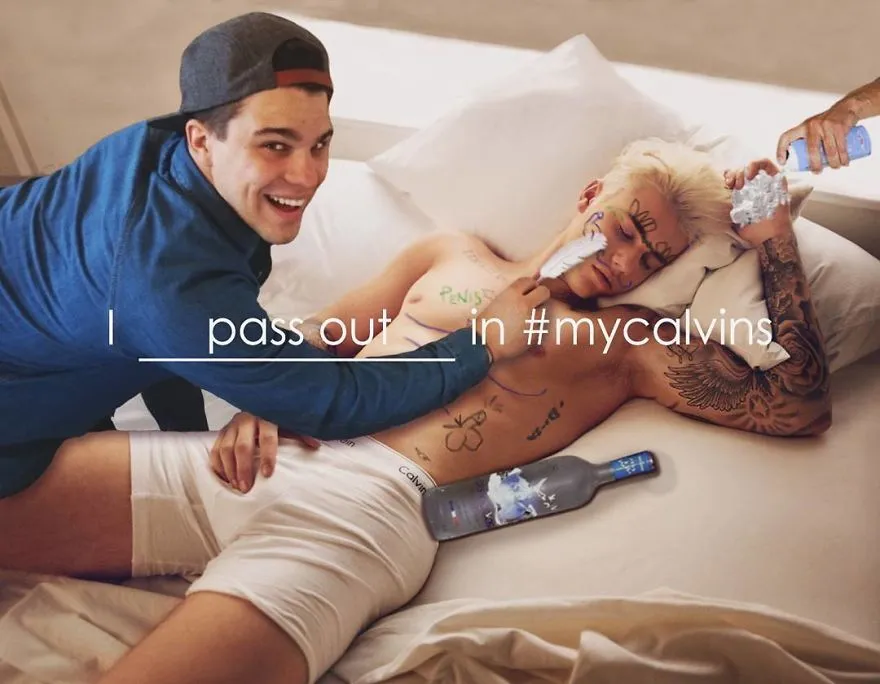 Average Rob despeja água sobre um jovem tatuado deitado na cama, numa paródia da campanha de roupa interior #mycalvins