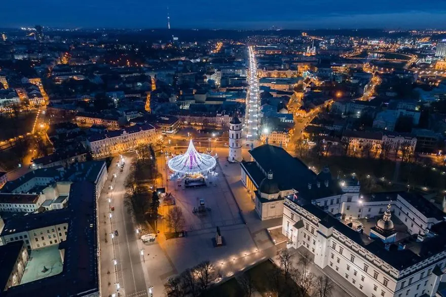 Vista aérea do centro de Vilnius à noite, com a árvore de Natal iluminada ao fundo da praça